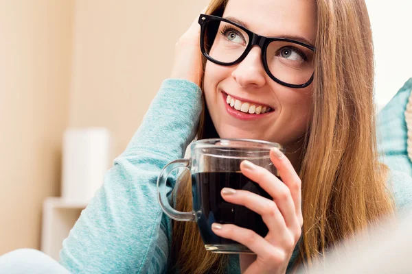 Glückliche junge Frau trinkt Kaffee zu Hause — Stockfoto