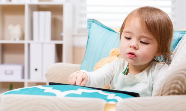 Toddler girl watching her tablet computer — Stock Photo, Image