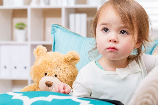 Ragazza bambino con il suo orsacchiotto e tablet pc — Foto Stock