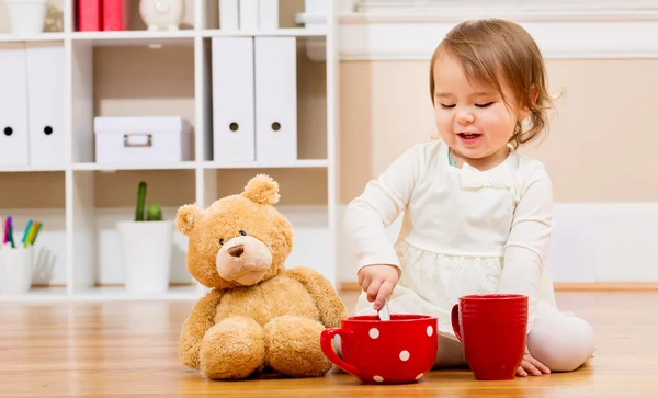 Girl having tea time with her teddy bear — Stock Photo, Image