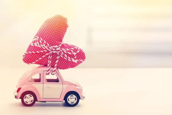 Miniature car carrying red heart cushion — Stock Photo, Image