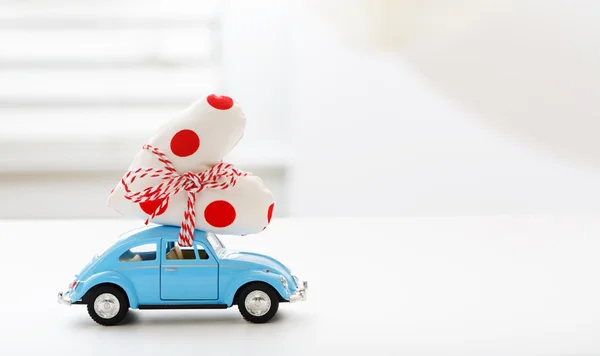 Miniature car carrying polka dots heart cushion — Stock Photo, Image