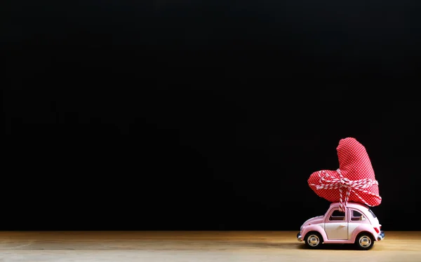 Carro miniatura carregando um coração vermelho — Fotografia de Stock