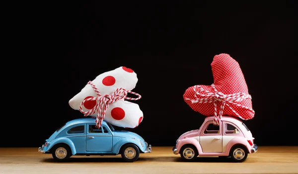Carros em miniatura carregando corações — Fotografia de Stock