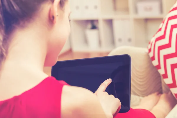 Giovane donna che utilizza un tablet sul suo divano — Foto Stock