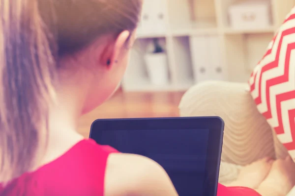 Young woman using a tablet on her couch — Stock Photo, Image