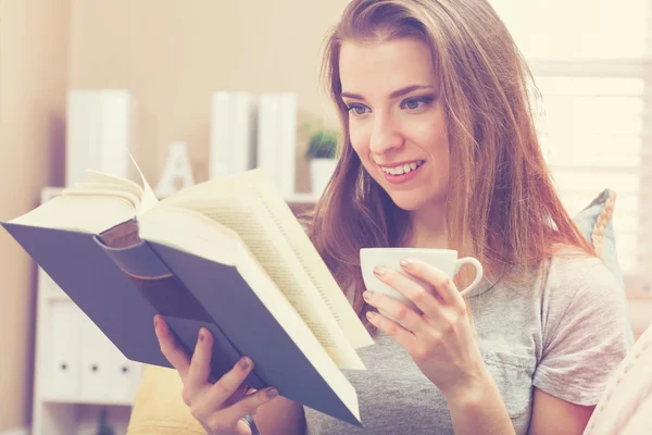 Kvinna läser en bok och dricker kaffe — Stockfoto