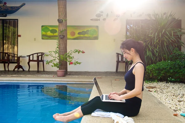 Girl work with laptop at pool