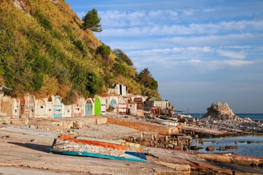 Ancona, Marche, Italy: the metropolitan beach of Passetto with the colorful doors of the caves carved into the rock to shelter the fishing boats clipart
