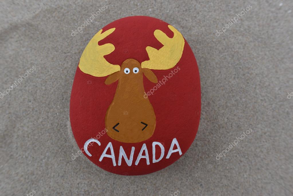 Visit Canada, elk design on a stone over the sand