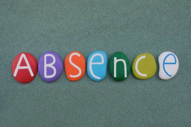 Creative composition of the word Absence with handmade multicolored painted stone letters over green sand