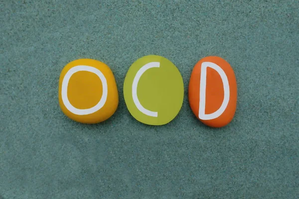 緑の砂の上に複数の色の石の文字で構成された創造的な手作りのロゴタイプ Ocd 強迫性障害 — ストック写真