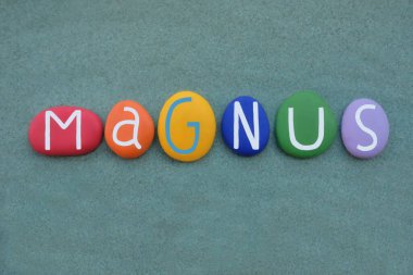 Magnus, İskandinav erkeksi ismi yeşil kumların üzerine çok renkli taş harflerle yazılmış.
