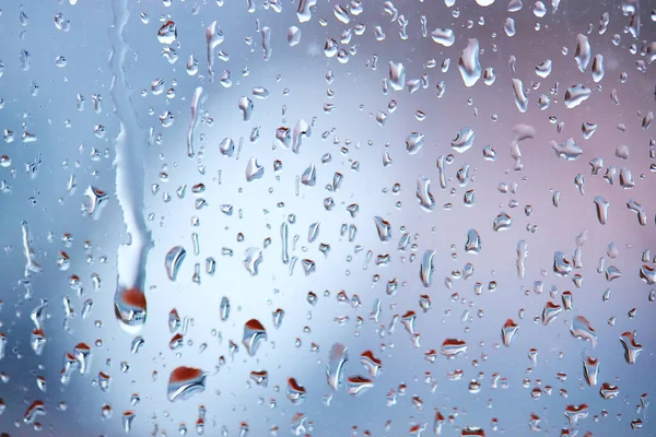 Капли дождя на стекле на спокойном красочном фоне. абстрактный фон — стоковое фото