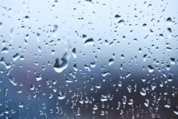 Капли дождя на стекле на спокойном красочном фоне. абстрактный холодный фон — стоковое фото
