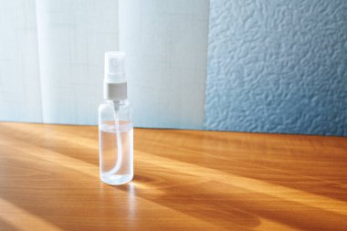 Ofis işyerindeki el dezenfektanı ahşap masa arkasında.