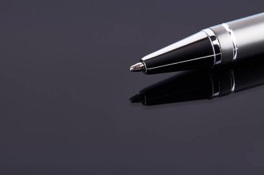 Lükslü gümüş renkli tükenmez kalem koyu arka planda izole edilmiş. kopyalama alanı. İmza, anlaşma, iş adamı konsepti