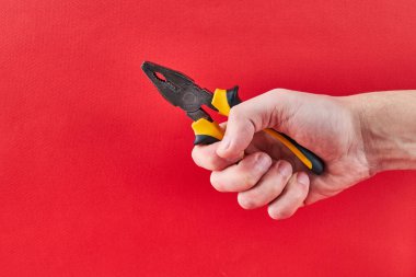 Kırmızı arka planda izole edilmiş pense var. basınç kavramı