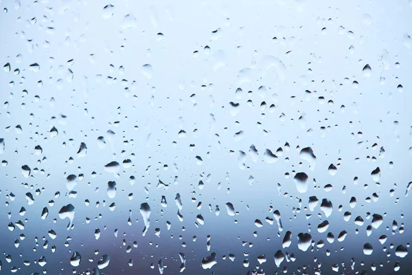Капли дождя на стекле на спокойном красочном фоне. абстрактный фон — стоковое фото