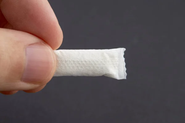Kafkasyalı kişi siyah arka planda tütün kesesi tutuyor. kopyalama alanı. Alternatif nikotin içmesi