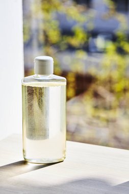 Boş el dezenfektanı, bulanık pencere altyapısı. kopyalama alanı. covid-19 sembolü konsepti. düşey yönelim