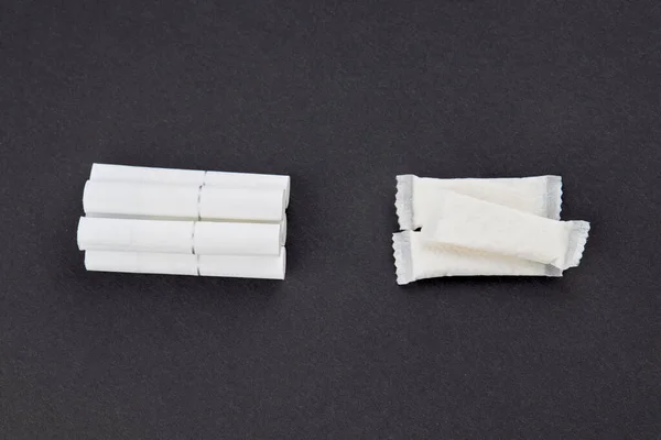 snus tütün kesesi ve sigara siyah arka planda