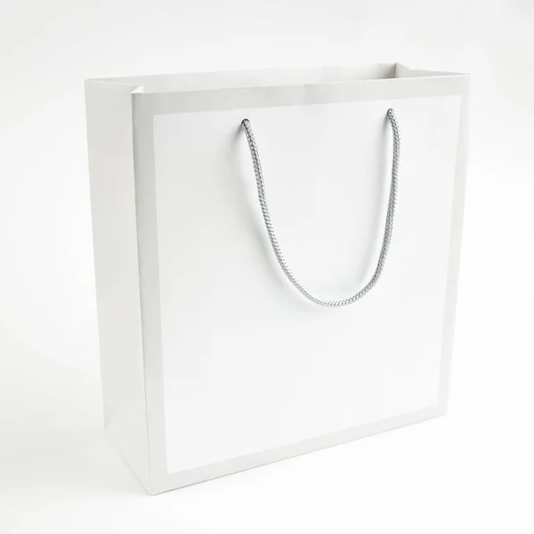 Mockup saco de papel cinza claro para design em um fundo cinza. espaço para texto. conceito de venda — Fotografia de Stock