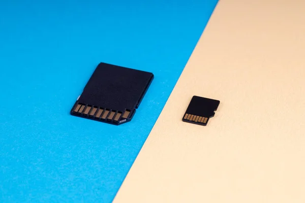 SD- und Micro-SD-Speicherkarte auf blauem und gelbem Hintergrund. verschiedene Arten von tragbaren Speichergeräten. Datenspeicherkonzept lizenzfreie Stockbilder