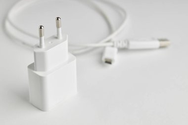 Beyaz usb şarjı ya da arka planda USB kablosu olan güç adaptörü. Taşınabilir bilgi aygıtları yükleniyor
