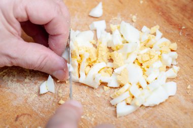 Mutfak tahtasında dilimlenmiş haşlanmış tavuk yumurtası. Yemek için malzemeyi hazırlıyorum. Ev yapımı yemek.