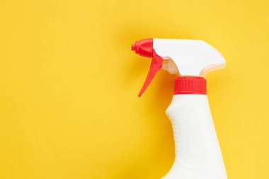 Parlak sarı bir arka planda boş bir kimyasal sprey şişesi. kopyalama alanı. temizlik ve çamaşır konsepti