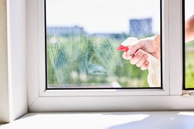Kirli pencereleri kimyasal spreyle temizlemek ya da yıkamak. ev işi temizleme konsepti