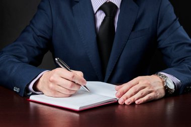 İş planı ve program konsepti. Kafkas işadamı defterine bir şeyler yazmış.