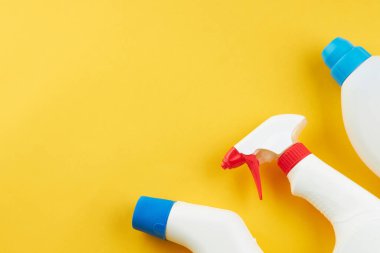 Parlak sarı arka planda boş kimyasallar şişeleri. kopyalama alanı. temizlik ve çamaşır konsepti