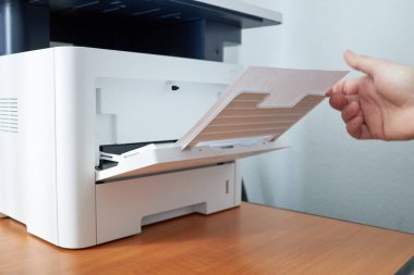 Ofiste fotokopi makinesine yakın görüntüsü olan işyeri.