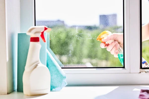 Schmutzige Fenster mit einem chemischen Spray reinigen oder waschen. Aufräumkonzept für den Haushalt Stockbild