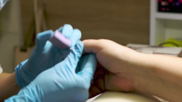 Manicure polimento e arquivamento unhas para o cliente feminino mais velho. caucasiano 50 anos mulher no salão de manicure. conceito de tratamento de beleza — Vídeo de Stock