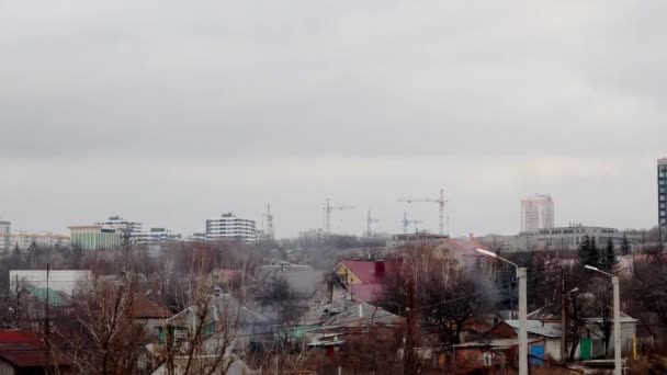 Ukrainische Stadtlandschaft in der Wintersaison. Baukräne im Hintergrund. Dramatische Abendwolken. Zeitraffer — Stockvideo