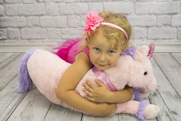 Enfant avec licorne rose Image En Vente