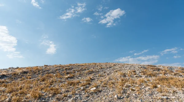 Övergivna hill och blå molnig himmel i sommar — Stockfoto