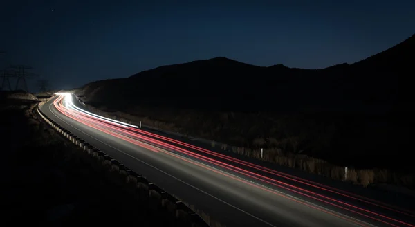 Lichtspuren von schnell fahrenden Autos — Stockfoto