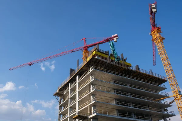 Bangunan kantor Residensial Modern konstruksi situs dan derek selama hari yang cerah dengan langit biru. — Stok Foto