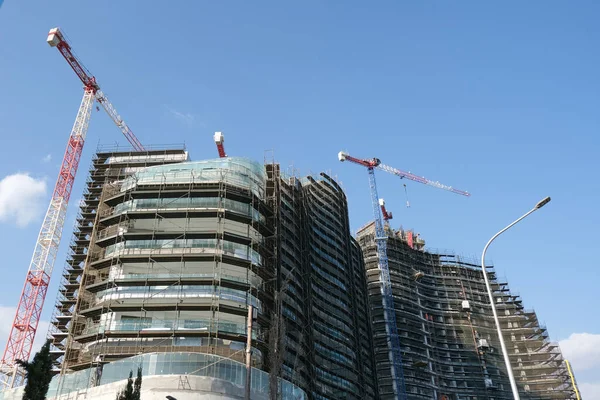 Moderne Bâtiment résidentiel de bureaux chantier de construction et grues lors d'une journée animée avec ciel bleu. — Photo