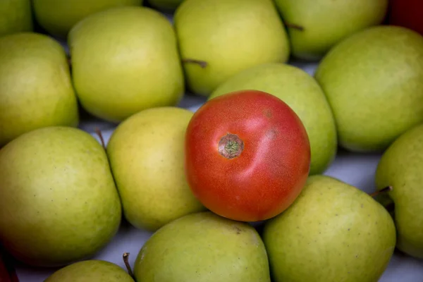 Verse rode tomatenvruchten die rusten op groene verse appels. Groenten en fruit — Stockfoto
