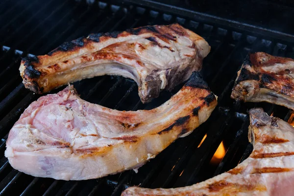 Raw Pork chops cooked on gas barbecue grill — Stock Fotó