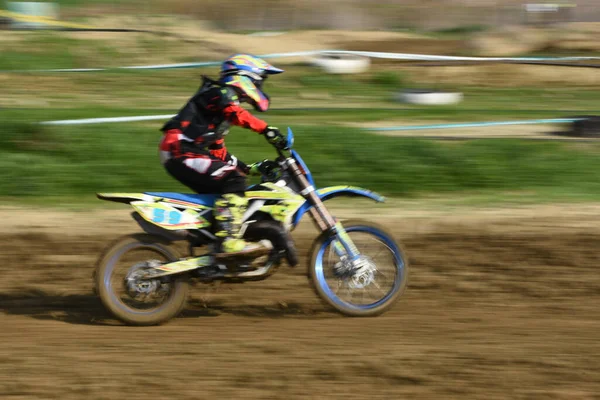 Atleta não reconhecido montando uma moto esportiva em uma corrida de motocross — Fotografia de Stock