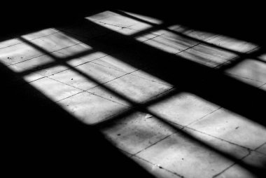 Parlak güneş ışığı boş bir odanın açık kırık penceresine giriyor..