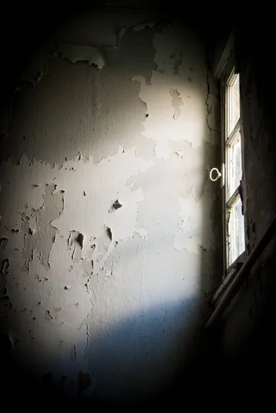 Helder zonlicht in een open gebroken raam van een verlaten kamer. — Stockfoto