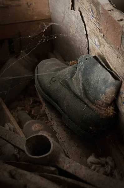 Een paar tweedehands versleten schoenen op een verlaten lege kamer. Verlaten plaatsen — Stockfoto