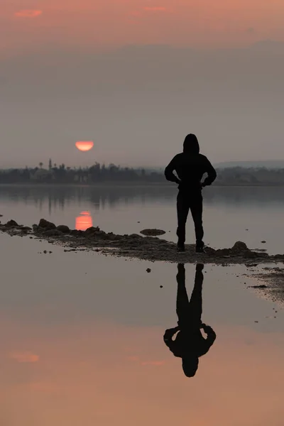 Неизвестный человек, стоящий и наслаждающийся закатом на озере. Ларнака-Кипр — стоковое фото